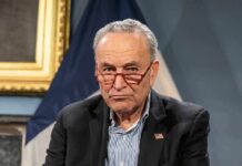 Genocide Shoutdown Rattles Schumer’s Rollout older man with red glasses and blazer