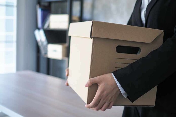 shutterstock_1691130073 person in a suit carrying a cardboard storage box