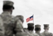 Alliance RIFT Over Trump’s Drill Cut American flag above blurred soldiers in formation