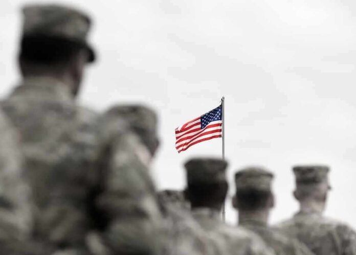 shutterstock_1711682233 American flag above blurred soldiers in formation