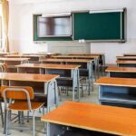 Empty classroom with rows of desks and a chalkboard