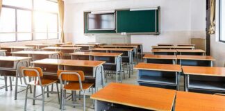 Empty classroom with rows of desks and a chalkboard