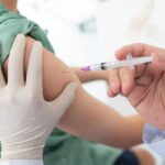 Healthcare worker giving an intramuscular injection in upper arm