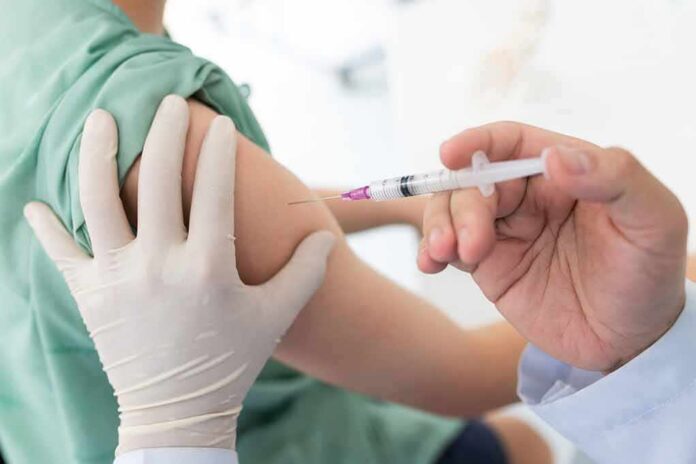 shutterstock_1740628409 Healthcare worker giving an intramuscular injection in upper arm