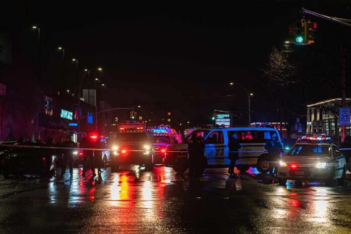 shutterstock_1903071622 Nighttime police scene with flashing lights on a wet city street