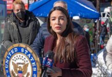 Defund Flip? AOC Laughs, Voters Bristle Woman speaking at outdoor press event with microphones and seal