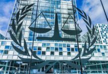Scales of justice emblem on glass facade of modern office building
