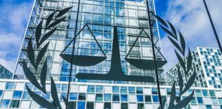 Washington Targets ICC With Sanctions Scales of justice emblem on glass facade of modern office building