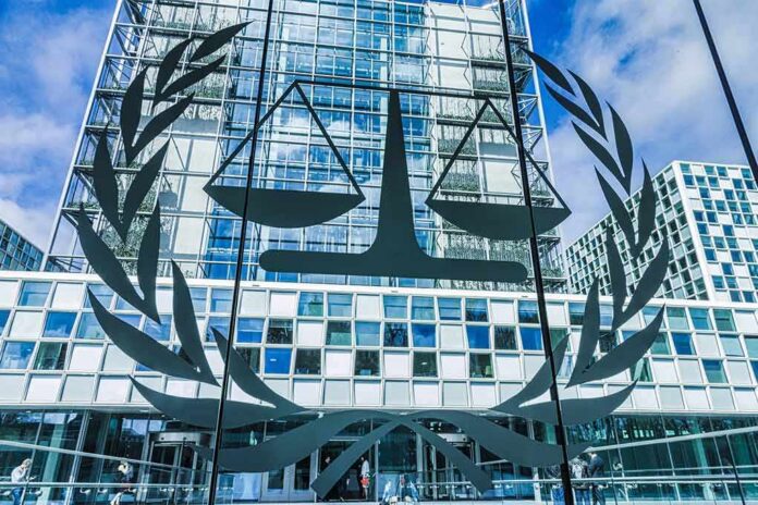 shutterstock_2067906602 Scales of justice emblem on glass facade of modern office building
