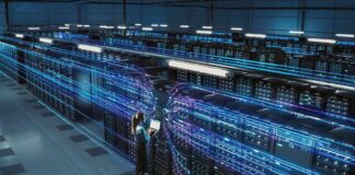 Technician with laptop in a large data center aisle