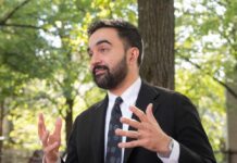 Court Freeze Hits NYC Tax Rollout Man in a suit gesturing while speaking outdoors