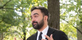 Court Freeze Hits NYC Tax Rollout Man in a suit gesturing while speaking outdoors