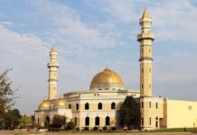Pre‑Dawn Loudspeakers Jolt Minneapolis Mosque with golden dome and two tall minarets under a partly cloudy sky