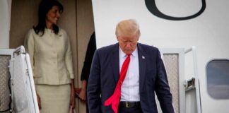 Trump’s Secret Turkey Flight Revealed man in suit with red tie walking down airplane stairs
