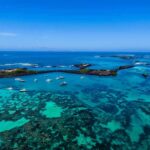 Boats anchored in turquoise lagoon with rocky islets
