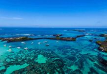 China Builds New Island Near Key Waters Boats anchored in turquoise lagoon with rocky islets