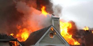 Manhunt Ends After Deadly Family Tragedy House engulfed in flames with heavy smoke from the roof