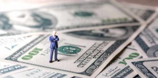 Billionaire Exodus Threat Rattles California Miniature businessman standing on US dollar bills
