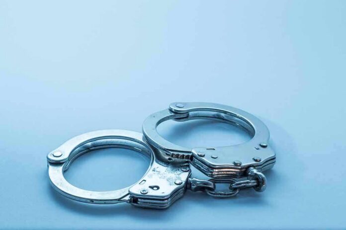shutterstock_1098085049-2 Metal handcuffs on a light blue surface