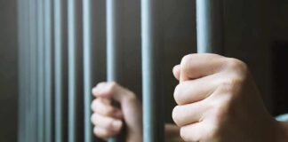 NC Prison Gamble Backfires? hands gripping prison bars
