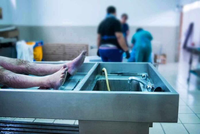cadaver on stainless autopsy table in clinical room