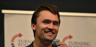 man speaking into a microphone on stage