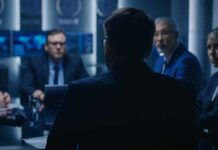 FBI Turmoil: Top Aide Suddenly Quits Business professionals in a dim conference room meeting
