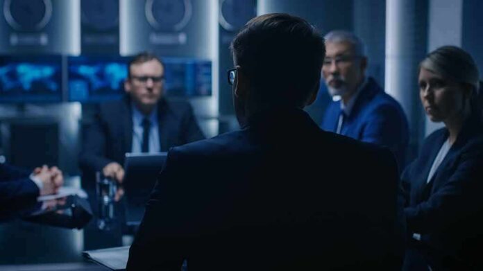shutterstock_1243021201 Business professionals in a dim conference room meeting