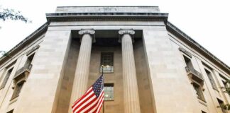 Demolition Threat Hangs Over Kennedy Center American flag hanging on a neoclassical government building