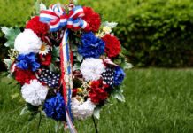 A patriotic memorial wreath adorned with red, white, and blue flowers