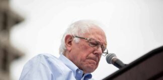 Bernie Sanders speaking at a podium with a microphone