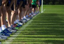 Runners lined up at a starting line on grass