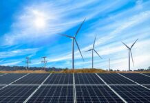 Solar Push Puts Ranch On Edge Solar panels with wind turbines in a sunny landscape