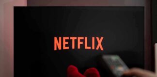 Bait-and-Switch Accusation Slams Netflix TV screen with Netflix logo and person holding remote