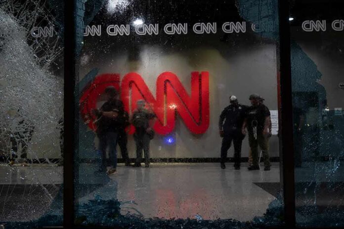 police officers inside lobby seen through shattered glass window