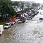 Flooded city street with stranded vehicles and traffic jam