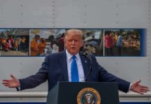 Trump Turns Iran’s Reparations Demand Back Donald Trump speaks at a podium with arms outstretched