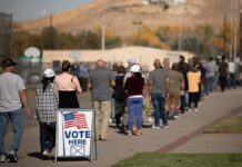 Election Earthquake Brewing In Iowa voters standing in a long line outside a polling place