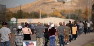 Election Earthquake Brewing In Iowa voters standing in a long line outside a polling place