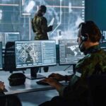 Military analysts at computers in a command center