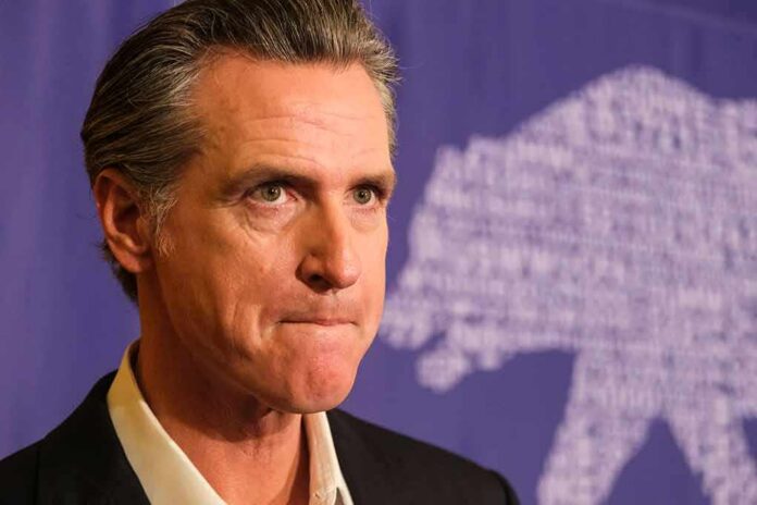 shutterstock_2368126823 Gavin Newsom at a press event with a purple backdrop