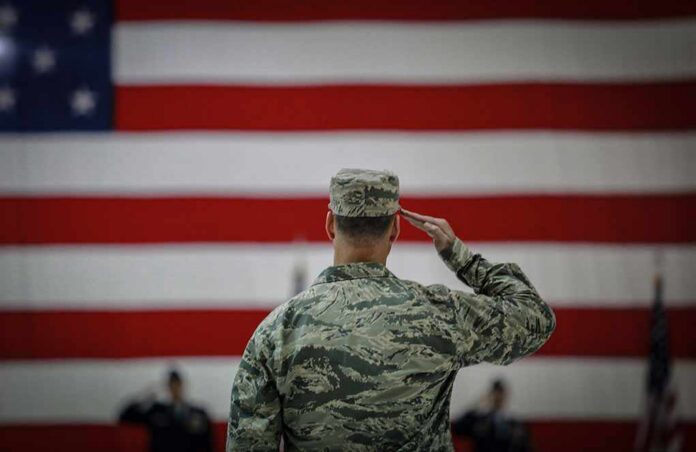 Soldier saluting before a large American flag
