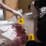 forensic investigators documenting a bloodstained crime scene