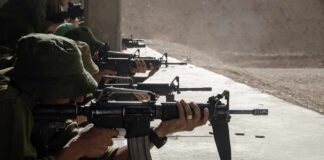 Soldiers lying prone firing rifles at a shooting range