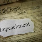 Torn paper with the word impeachment on the U.S. Constitution