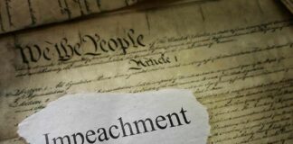 Clock-Stopping Move Freezes Impeachment Torn paper with the word impeachment on the U.S. Constitution
