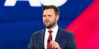 man in suit speaking at a podium