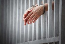 Jeopardy Champ in Jail – Bond Denied! See Why handcuffed hands resting through prison bars