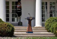 DOJ Cornered: Trump Drops Capital Bomb Podium with presidential seal in a garden colonnade