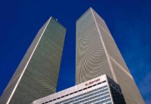 Sickening: Ground Zero Defaced – See How Twin rectangular skyscrapers rising above a hotel facade against a clear blue sky